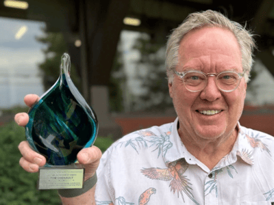 Tom Chenault holding his ANMP Lifetime Achievement Award